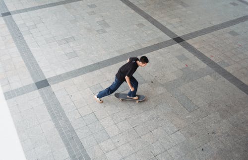 在城市人行道上骑滑板的人 · 免费素材图片