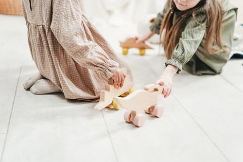 两个女孩玩木制玩具的照片 · 免费素材图片