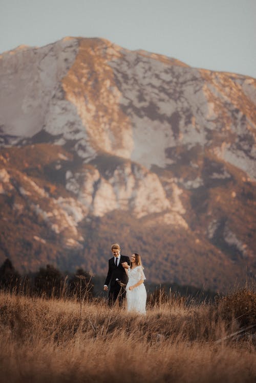 新郎和妻子站在山附近 · 免费素材图片