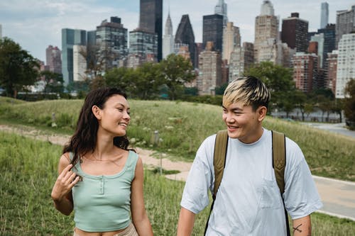 美满的多种族夫妇在现代城市的草地上 · 免费素材图片