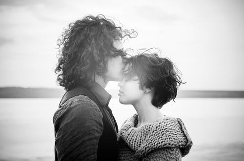 男人亲吻女人的额头的灰度照片 · 免费素材图片