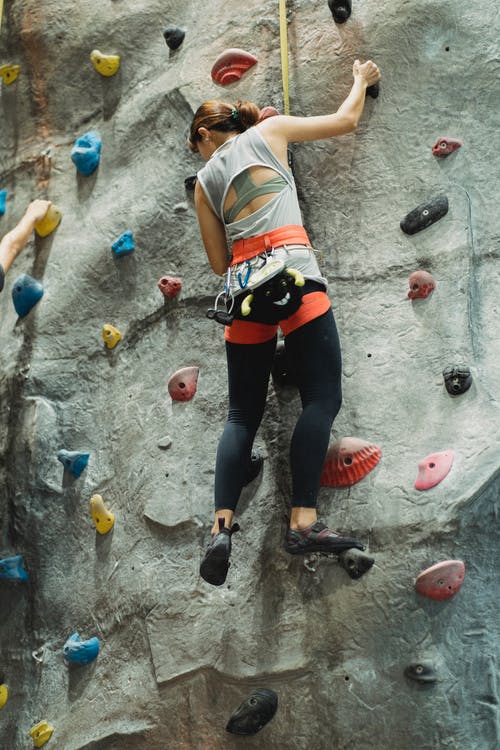在攀岩中心的墙上爬的女人 · 免费素材图片
