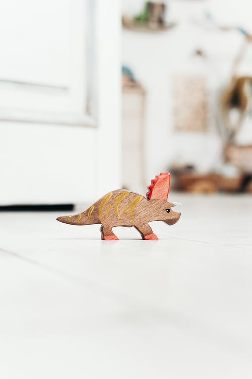 白色地板上的棕色恐龙玩具 · 免费素材图片
