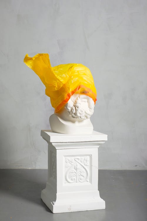 雕塑覆盖在白色背景上的黄色塑料 · 免费素材图片