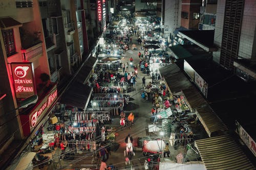 夜间在建筑物附近街道上行走的人的航拍 · 免费素材图片