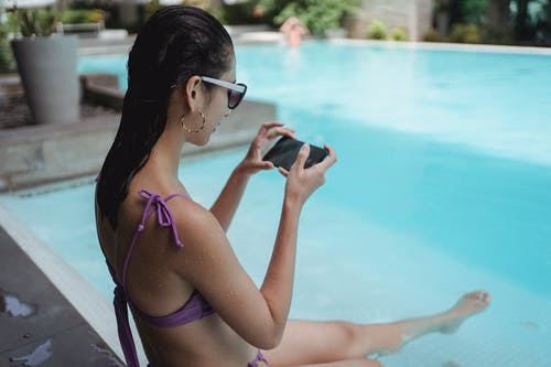 合适的女人在游泳池边放松和拍照的双腿 · 免费素材图片
