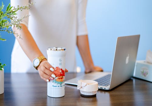 Macbook在白色不倒翁旁边的浅焦点照片 · 免费素材图片