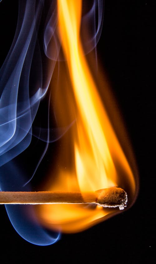 火柴棍给人以白色烟雾的橙色火焰 · 免费素材图片