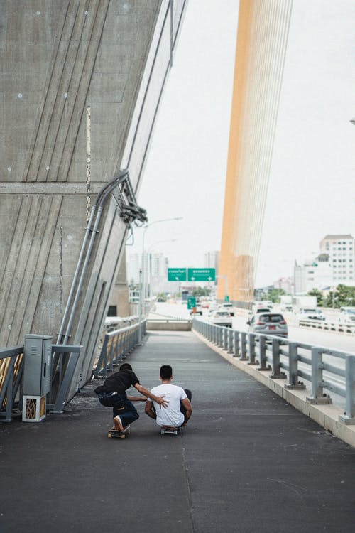 夏天在城市桥梁上溜冰的认不出来的运动员 · 免费素材图片