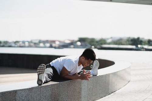 亚洲运动员做拆分和伸展身体在城市长廊 · 免费素材图片