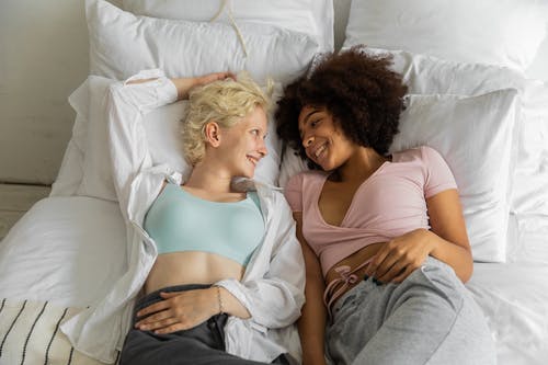 幸福的多种族女同性恋夫妇一起在床上放松 · 免费素材图片