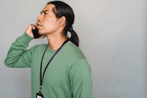 严重的美国原住民男子在智能手机上交谈 · 免费素材图片