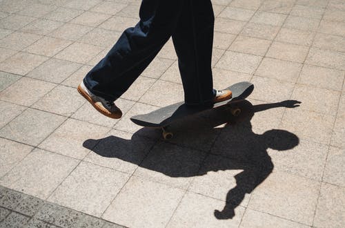 作物溜冰者在人行道上骑滑板 · 免费素材图片