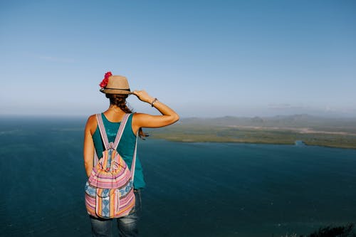 不露面的旅行者，从山上欣赏海洋的背包 · 免费素材图片