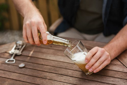 男子倒啤酒在玻璃杯子里野餐 · 免费素材图片