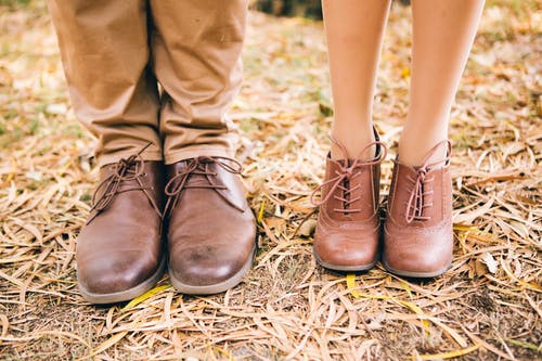 一对夫妇穿着经典的棕色皮鞋的照片 · 免费素材图片