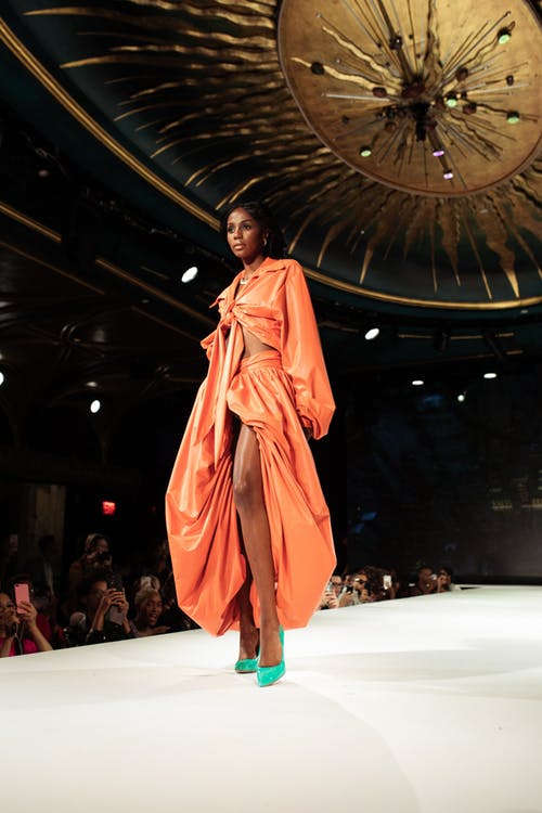 站在白色的地板上的橙色长袍的女人 · 免费素材图片