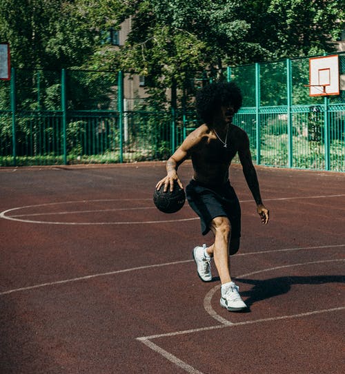 黑色的衬衫和黑色的裤子打篮球的女人 · 免费素材图片