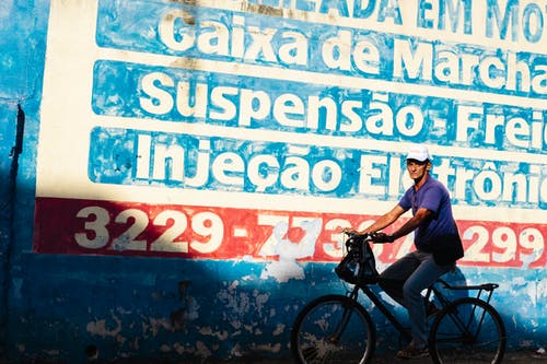 涂鸦墙附近的人骑自行车的照片 · 免费素材图片