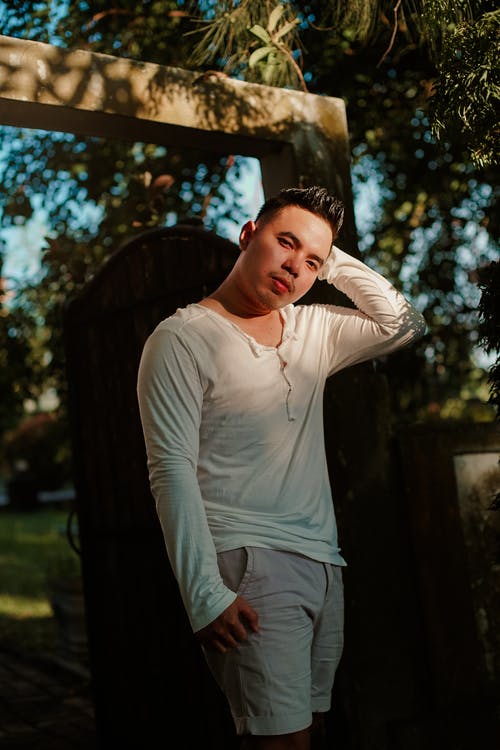 穿白色毛衣和灰色短裤的男人的照片 · 免费素材图片