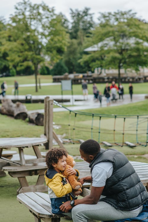 黑人父亲和儿子在公园里看着对方 · 免费素材图片