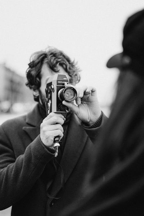 拿着照相机的黑夹克的人 · 免费素材图片