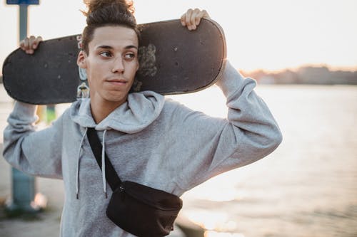 自信的年轻人与滑板 · 免费素材图片