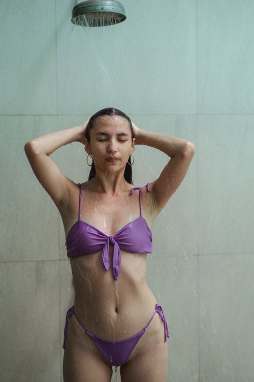 紫罗兰色比基尼洗身体在浴室的苗条性感女人 · 免费素材图片