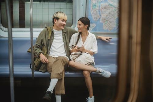 坐在火车和谈话的愉快的年轻种族夫妇 · 免费素材图片