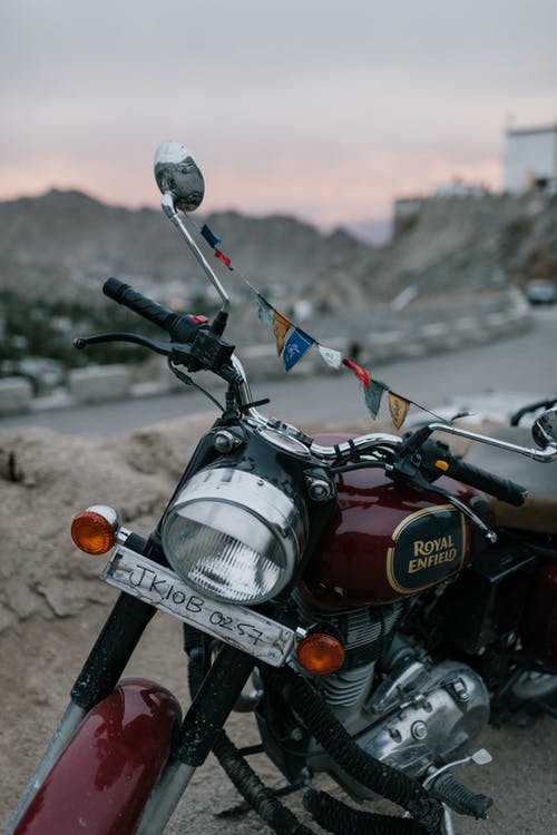 老年的摩托车在日落时分停在山区道路上 · 免费素材图片