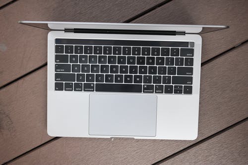 木质表面上的macbook Pro · 免费素材图片