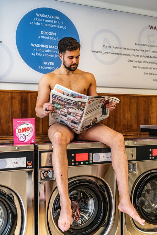 坐在前排洗衣机上的男人 · 免费素材图片