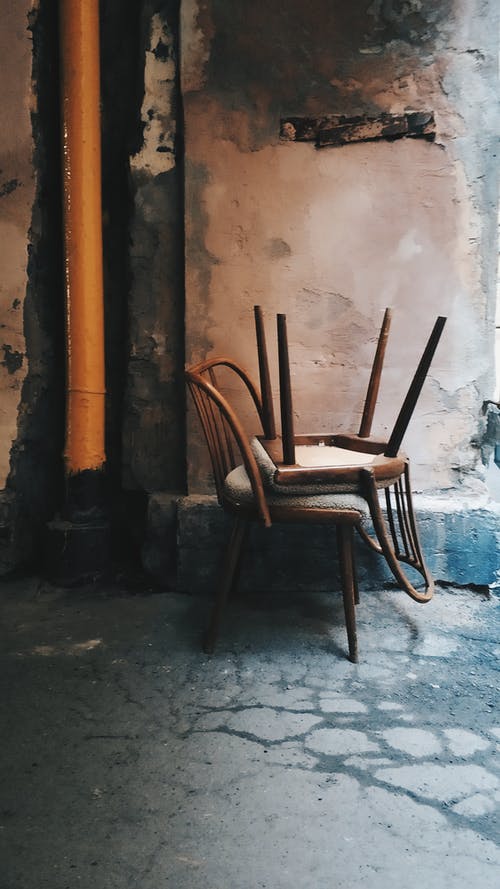棕色墙旁边的棕色木椅 · 免费素材图片