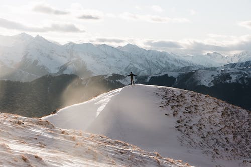 站在白雪皑皑的山上的人 · 免费素材图片