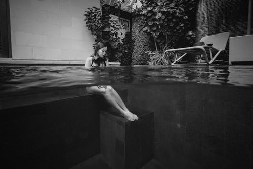 女人坐在水下的灰度摄影 · 免费素材图片