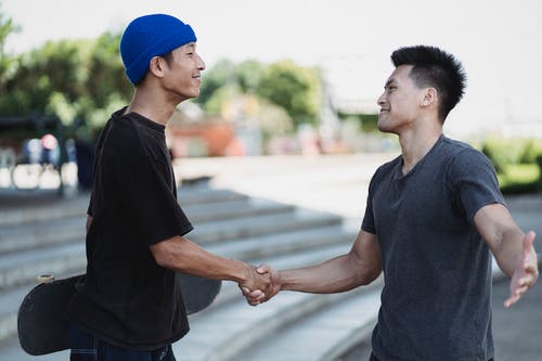 美满的亚洲男子在阳光明媚的大街上握手 · 免费素材图片