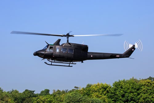 黑色直升机飞过绿树 · 免费素材图片