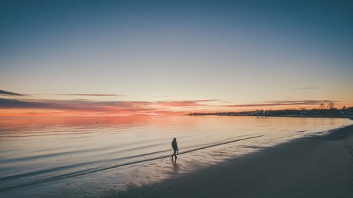 在日落海滩散步的人 · 免费素材图片