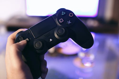 持有索尼ps4 Dualshock 4的人 · 免费素材图片