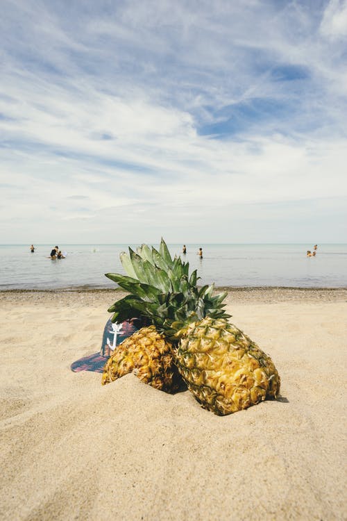 在沙滩上的两个菠萝 · 免费素材图片