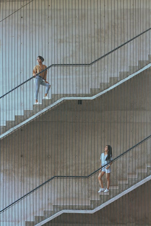T恤和蓝色牛仔牛仔裤走上楼梯的人 · 免费素材图片