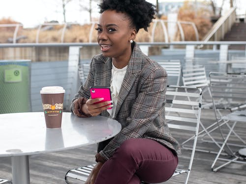 女人拿着智能手机与粉红色的情况下 · 免费素材图片