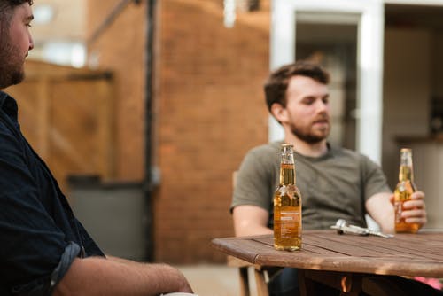 男子在户外露台开会期间喝啤酒 · 免费素材图片