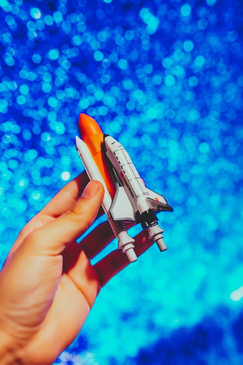 持有太空火箭玩具的人 · 免费素材图片