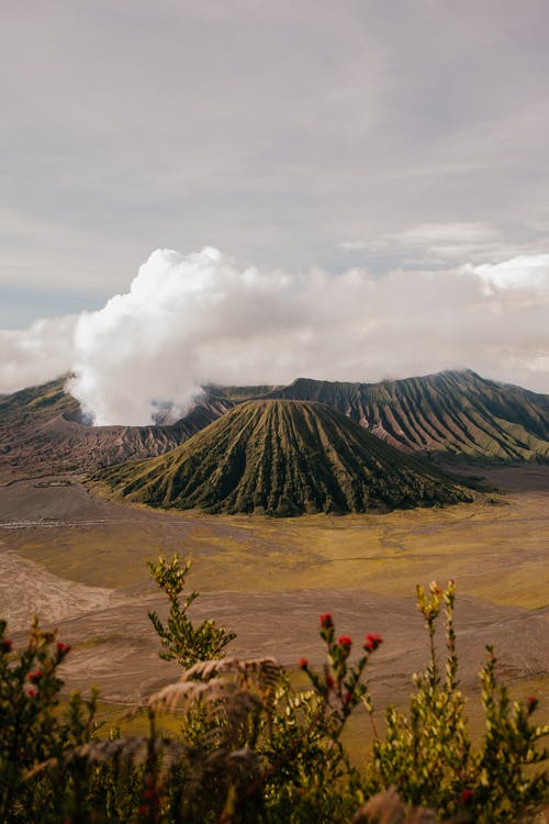 在沙漠谷在云层下的火山山脉 · 免费素材图片