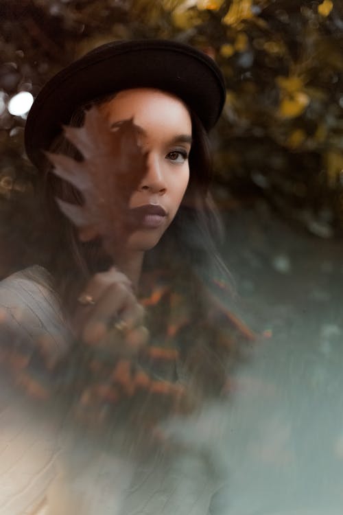 女人覆盖着棕色的叶子的脸 · 免费素材图片