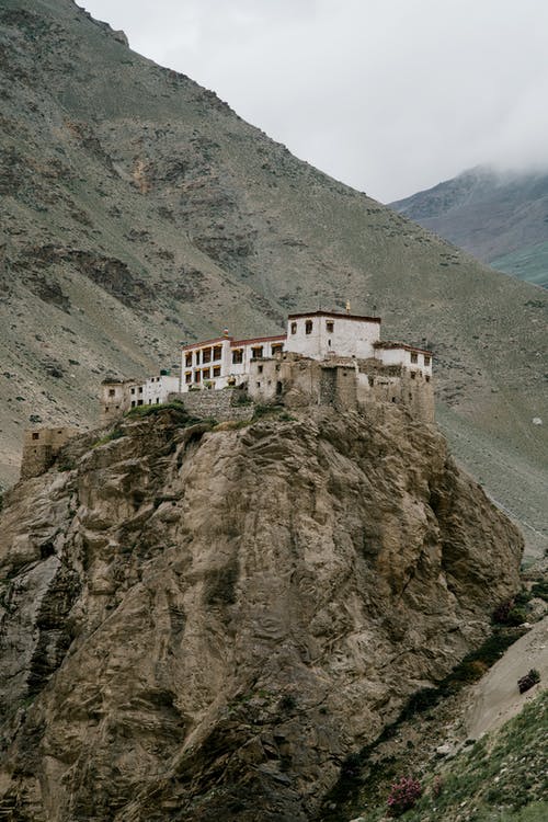 老佛教寺院坐落在山谷对薄雾笼罩的天空山峰 · 免费素材图片