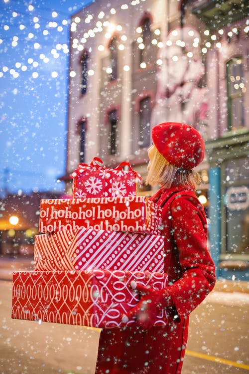 女人抱着三个红色的圣诞礼物盒 · 免费素材图片