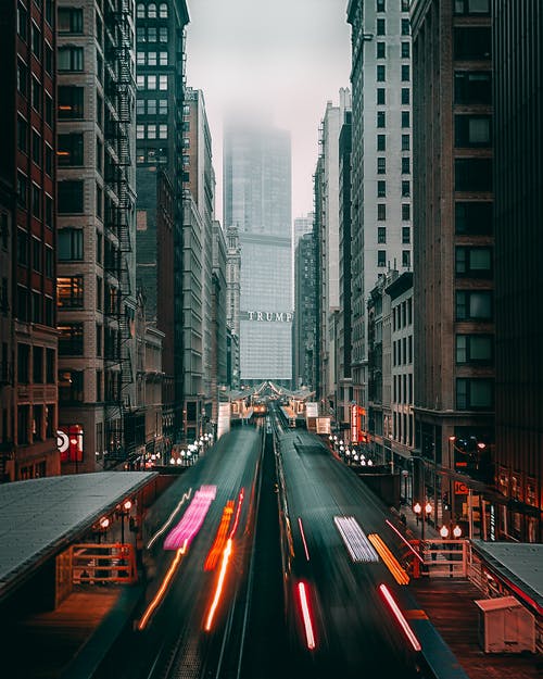 高层建筑之间的道路上的汽车 · 免费素材图片