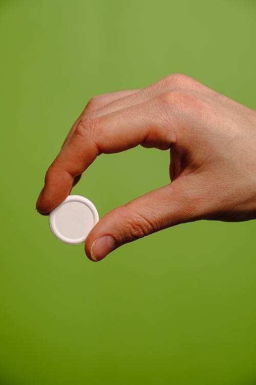 白色圆形按钮和人的手 · 免费素材图片